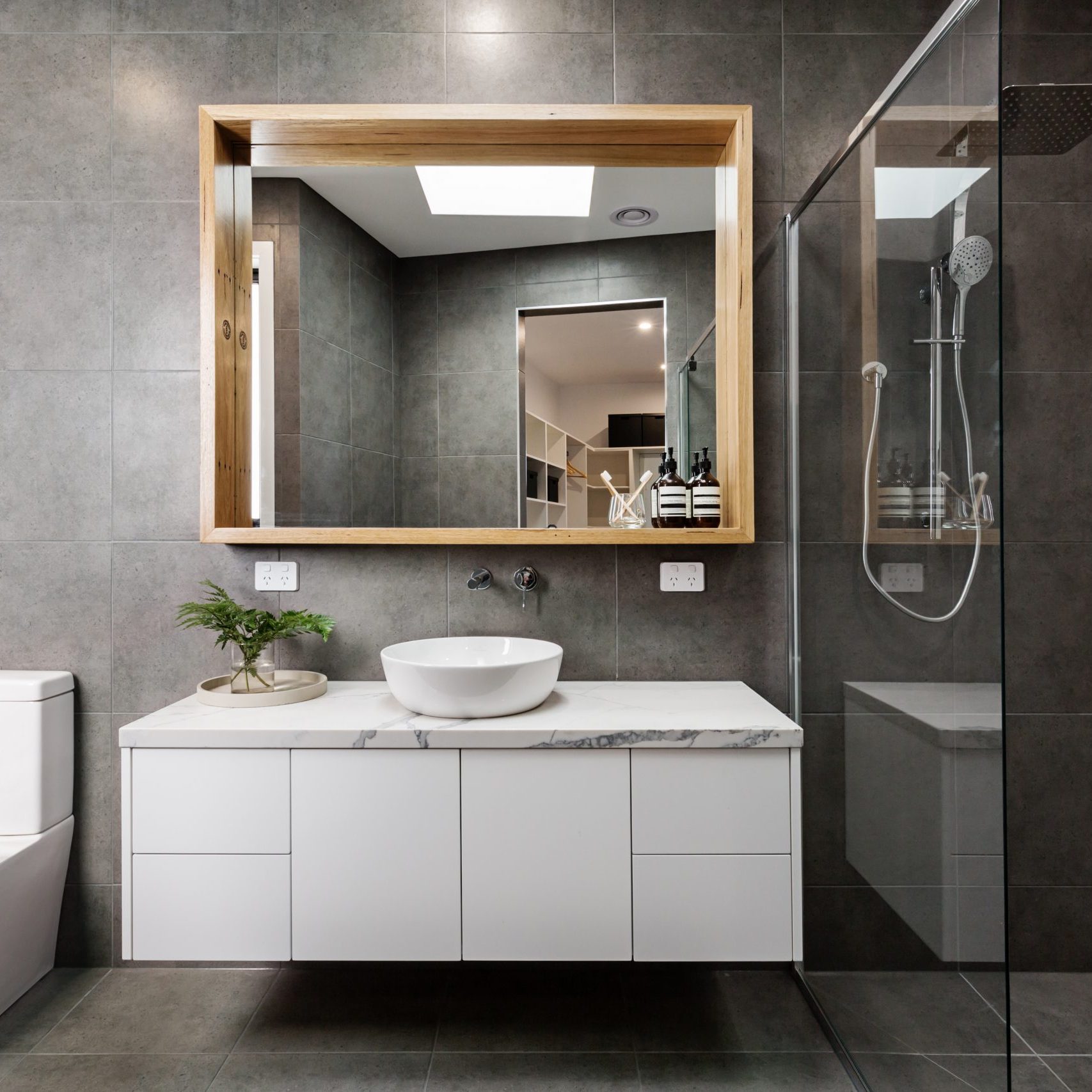 Modern grey designer bathroom with herringbone shower tiling